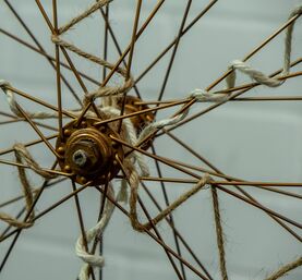 Eine alte mit Hanfkordel verzierte Fahrradfelge.